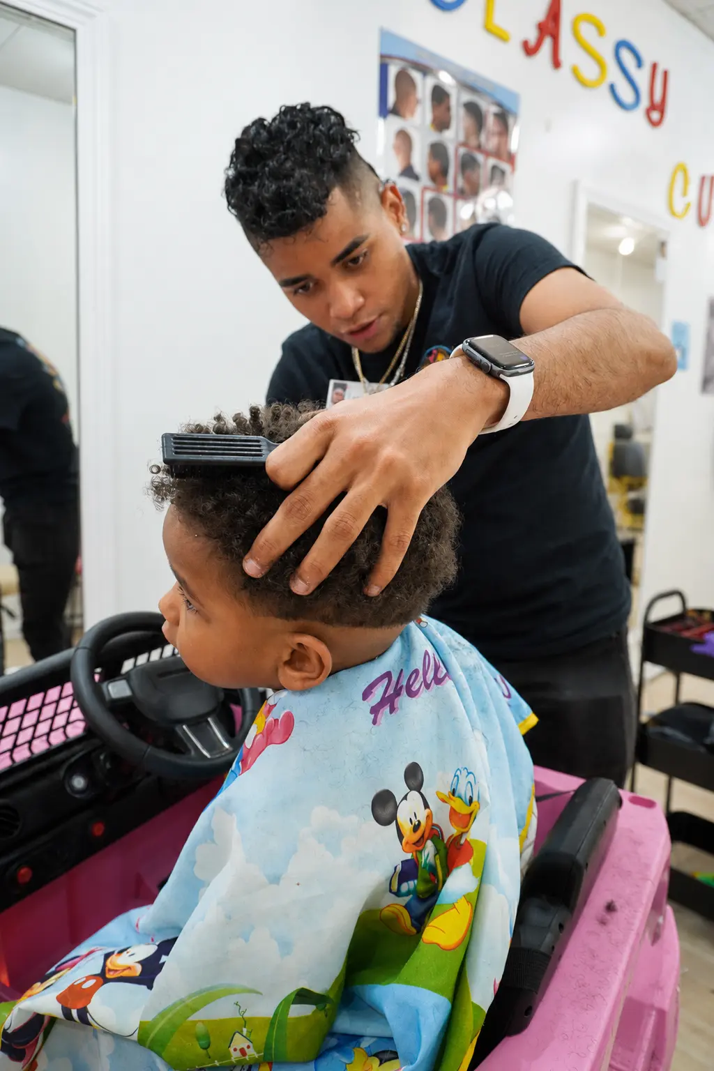 Barber combing out a child's curly hair