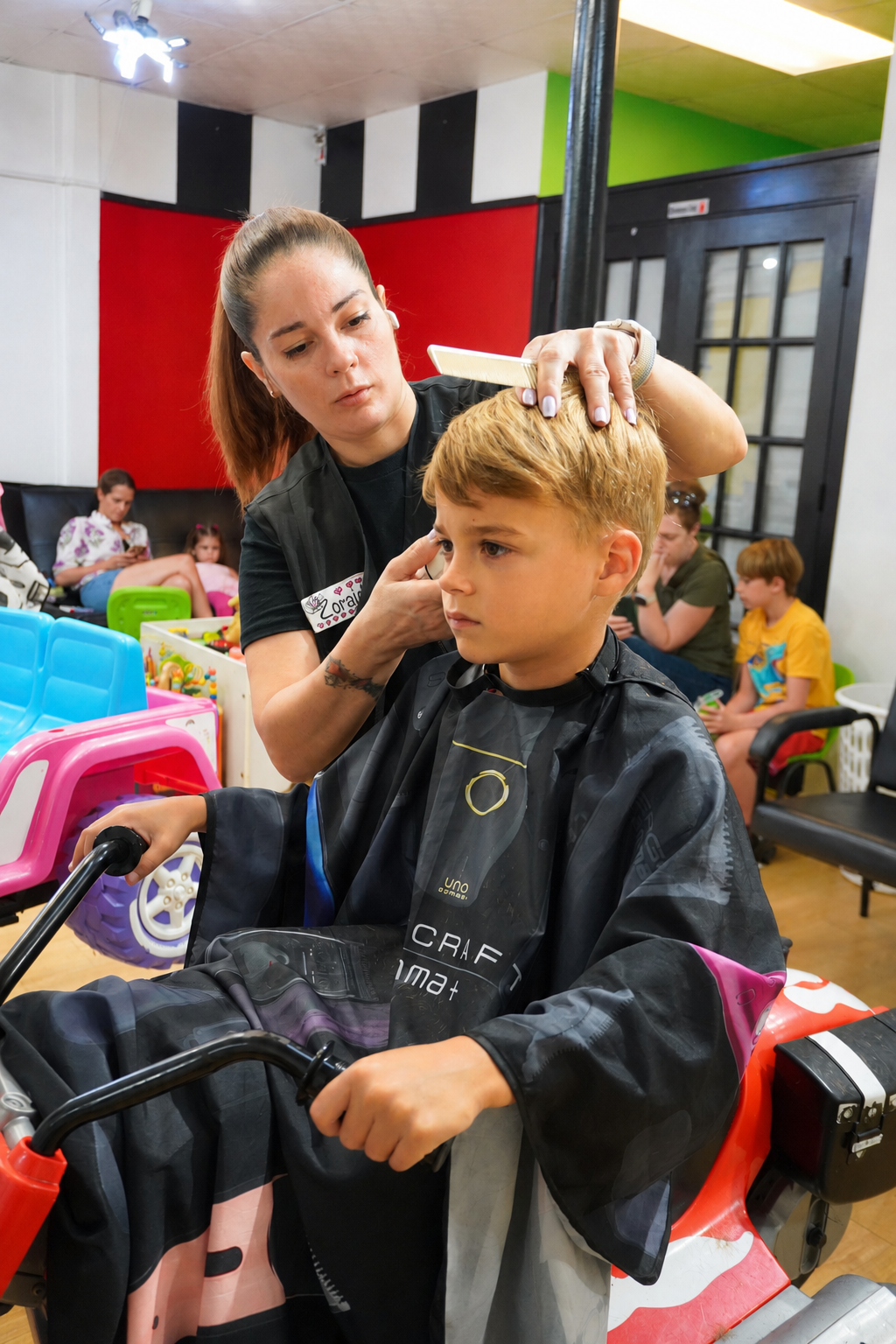 Stylist combing a boy's hair in a motorcycle chair