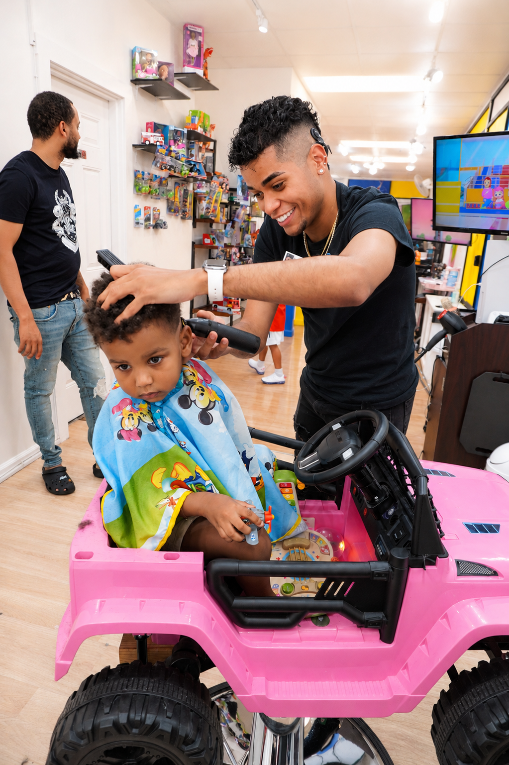 Leo cutting a child's hair in a pink Jeep chair at Children's Classy Cuts Salon